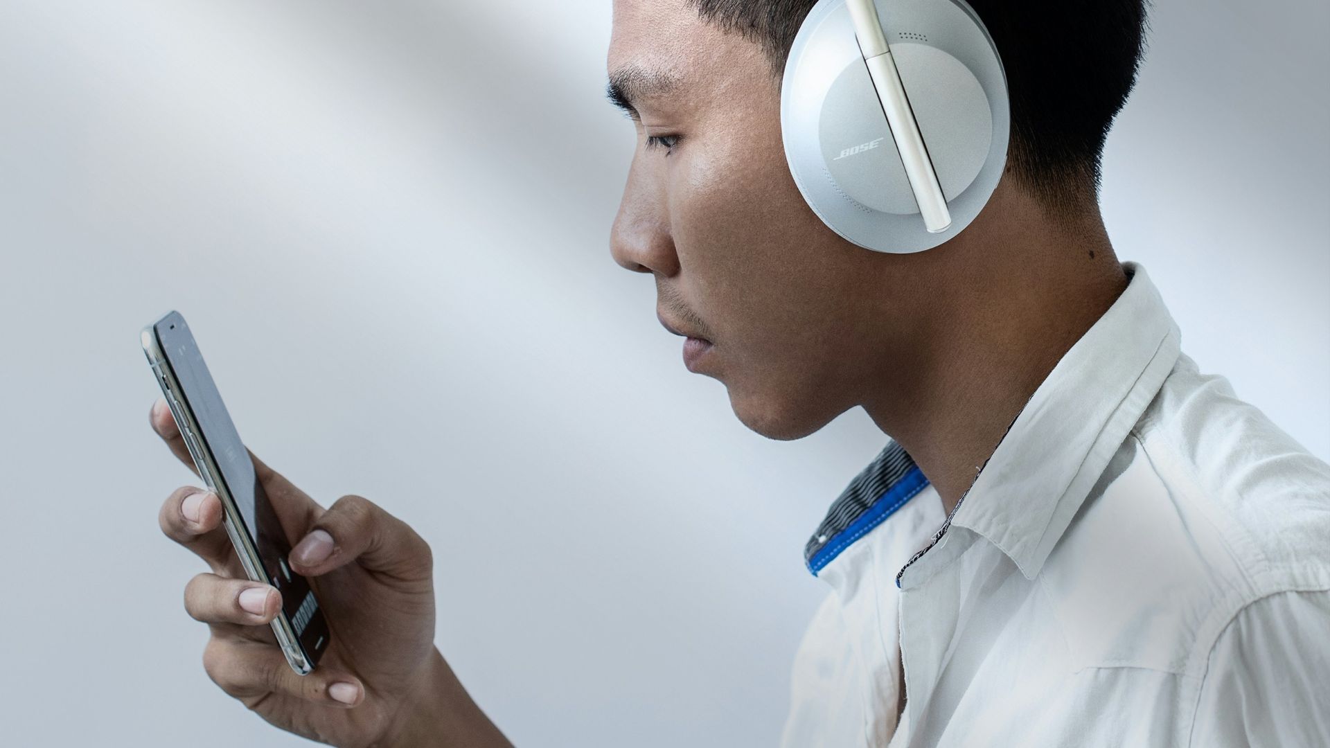 man in white dress shirt holding smartphone