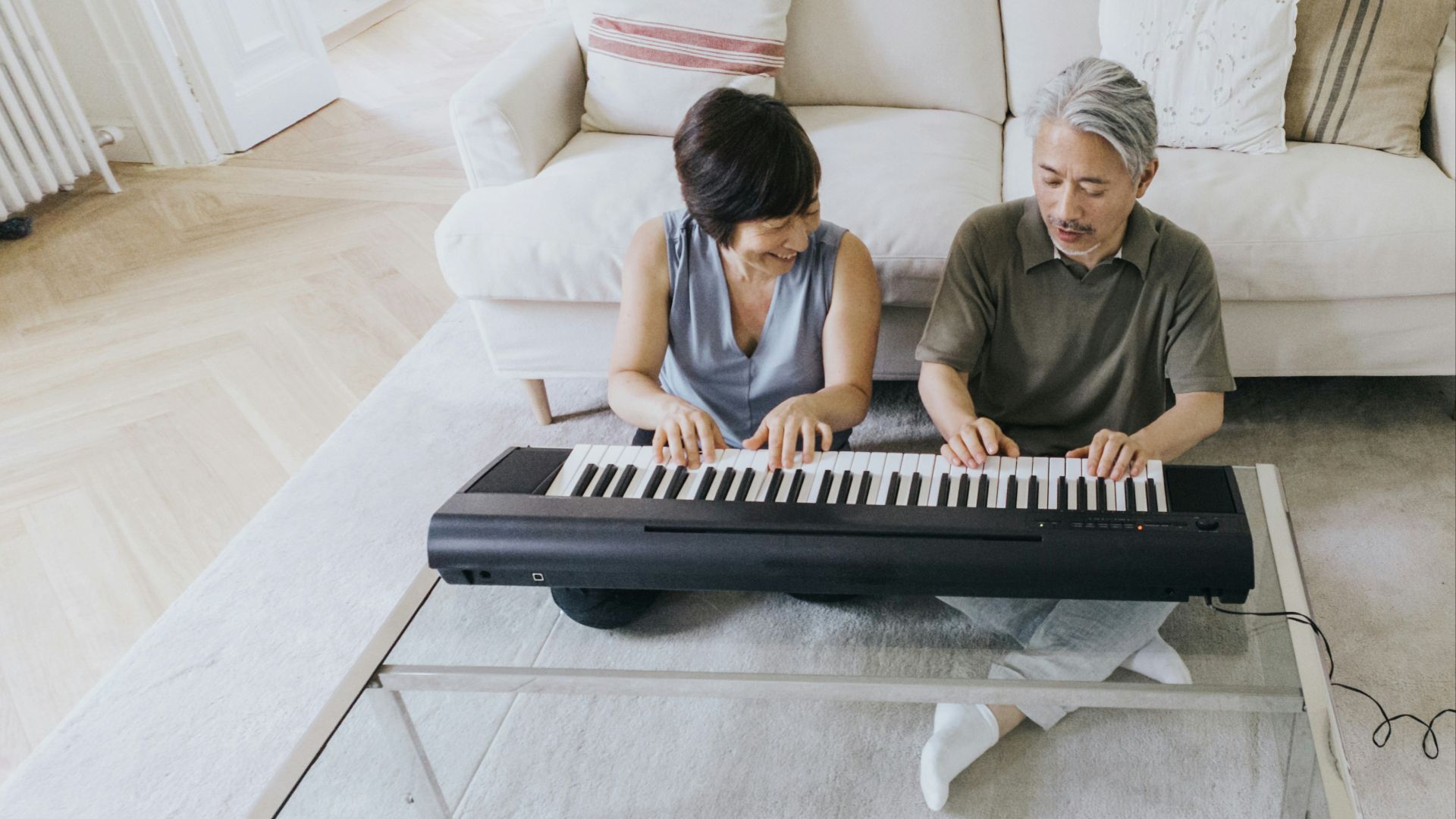 a man and a woman playing a piano on a couch