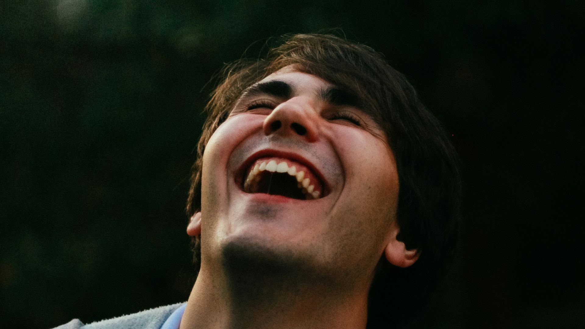man in gray sweater smiling