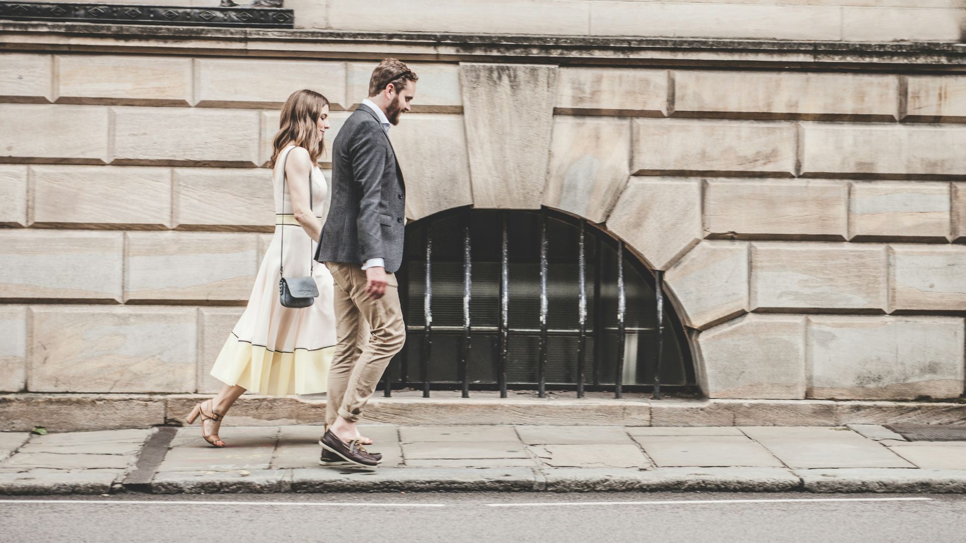 man and woman walking beside a road during daytime