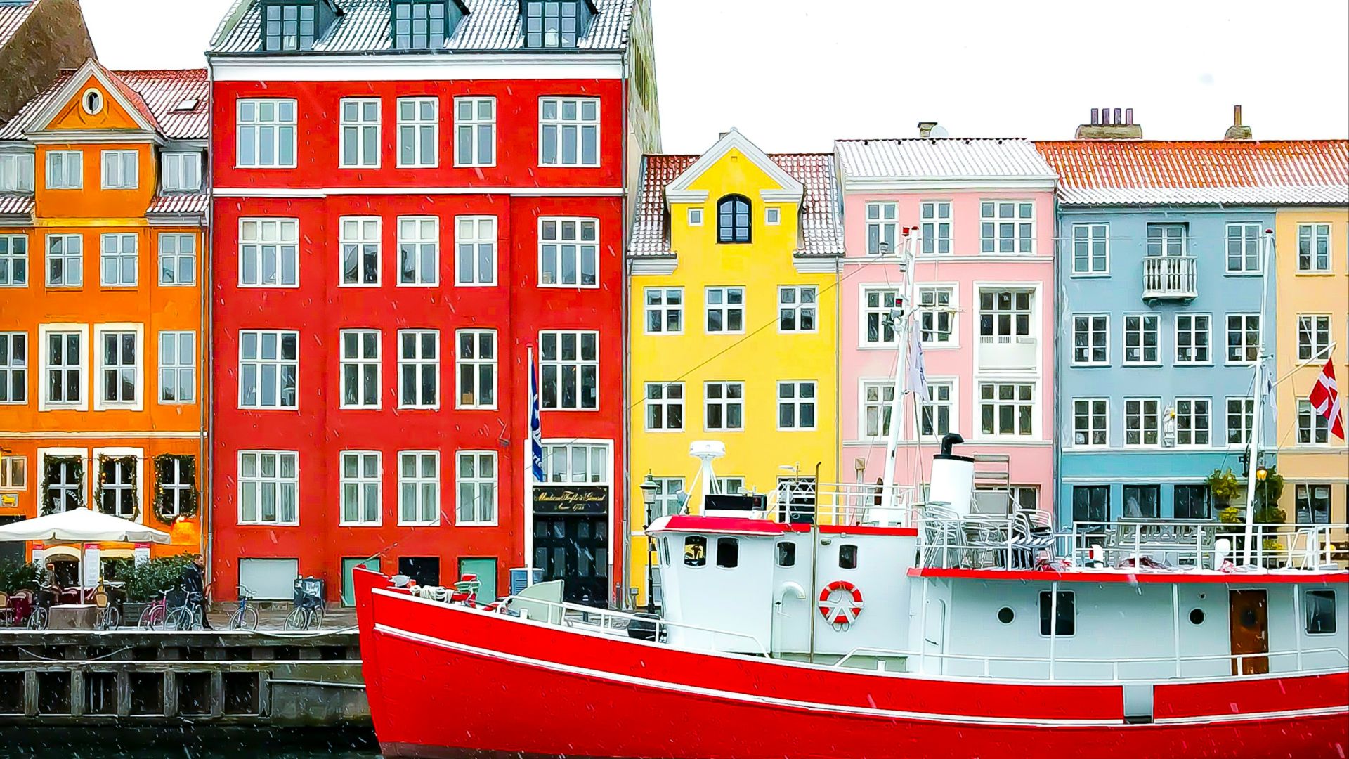 assorted-color buildings near red boat docked on port during daytime