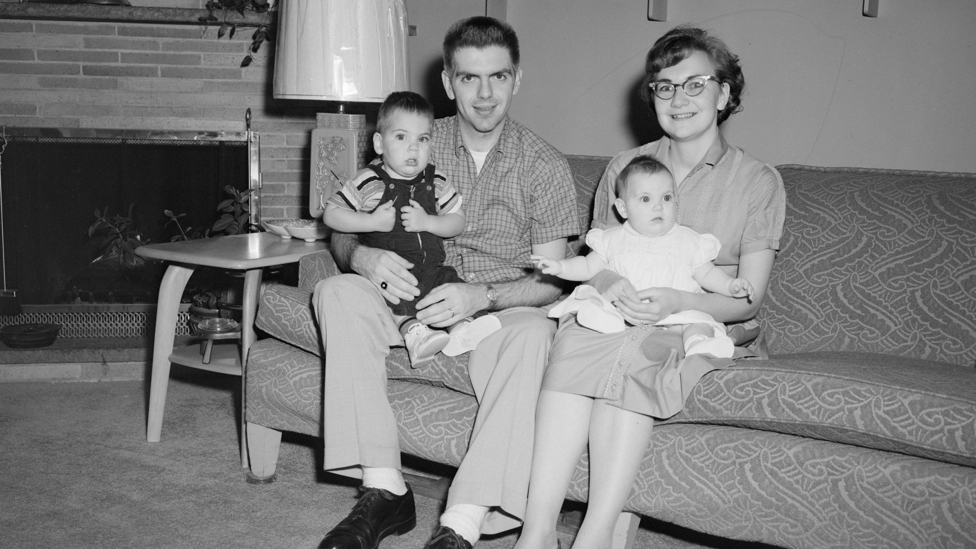 grayscale photo of 2 boys sitting on couch