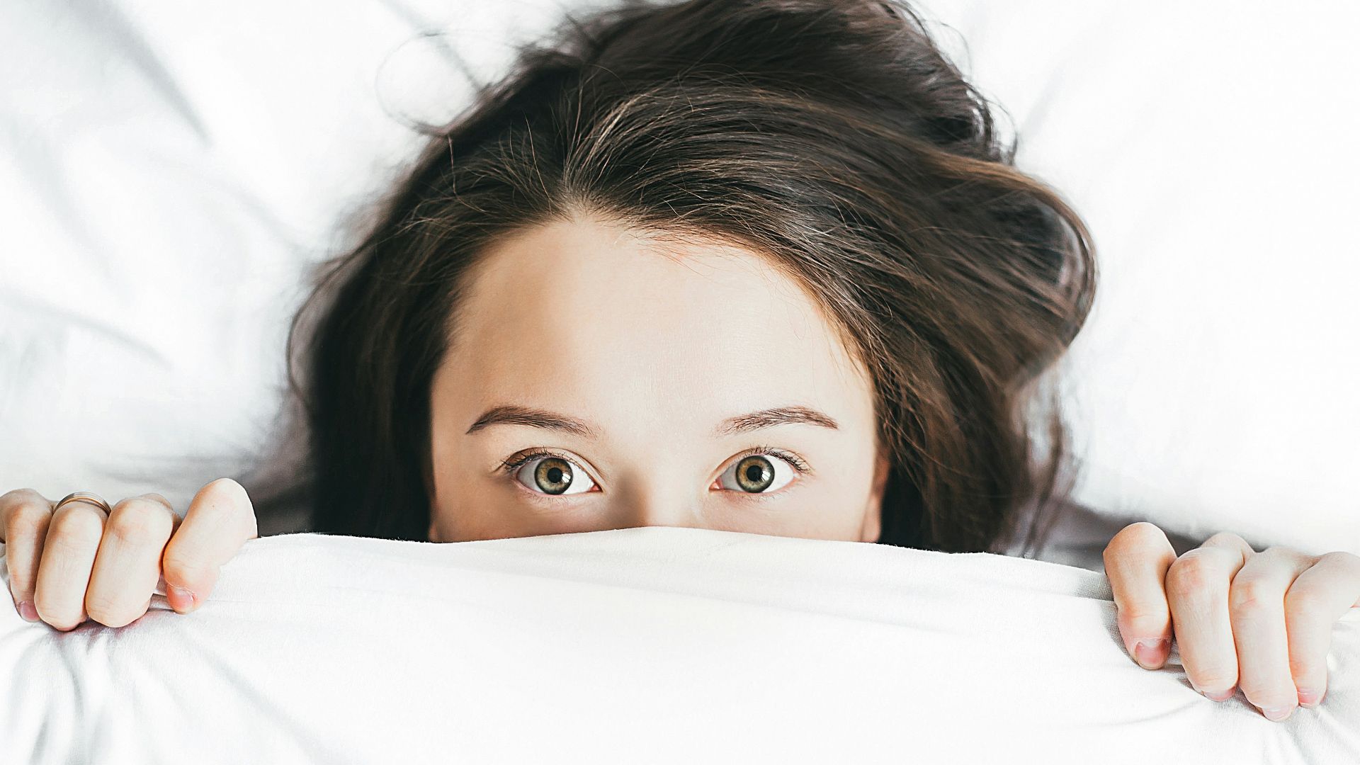 woman covering her face with blanket