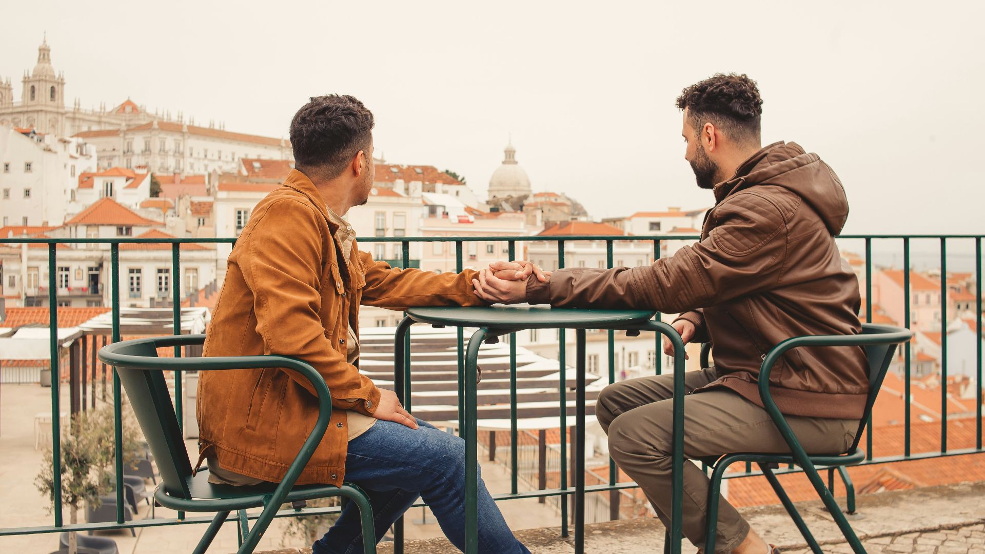 a couple of men sitting at a table next to each other