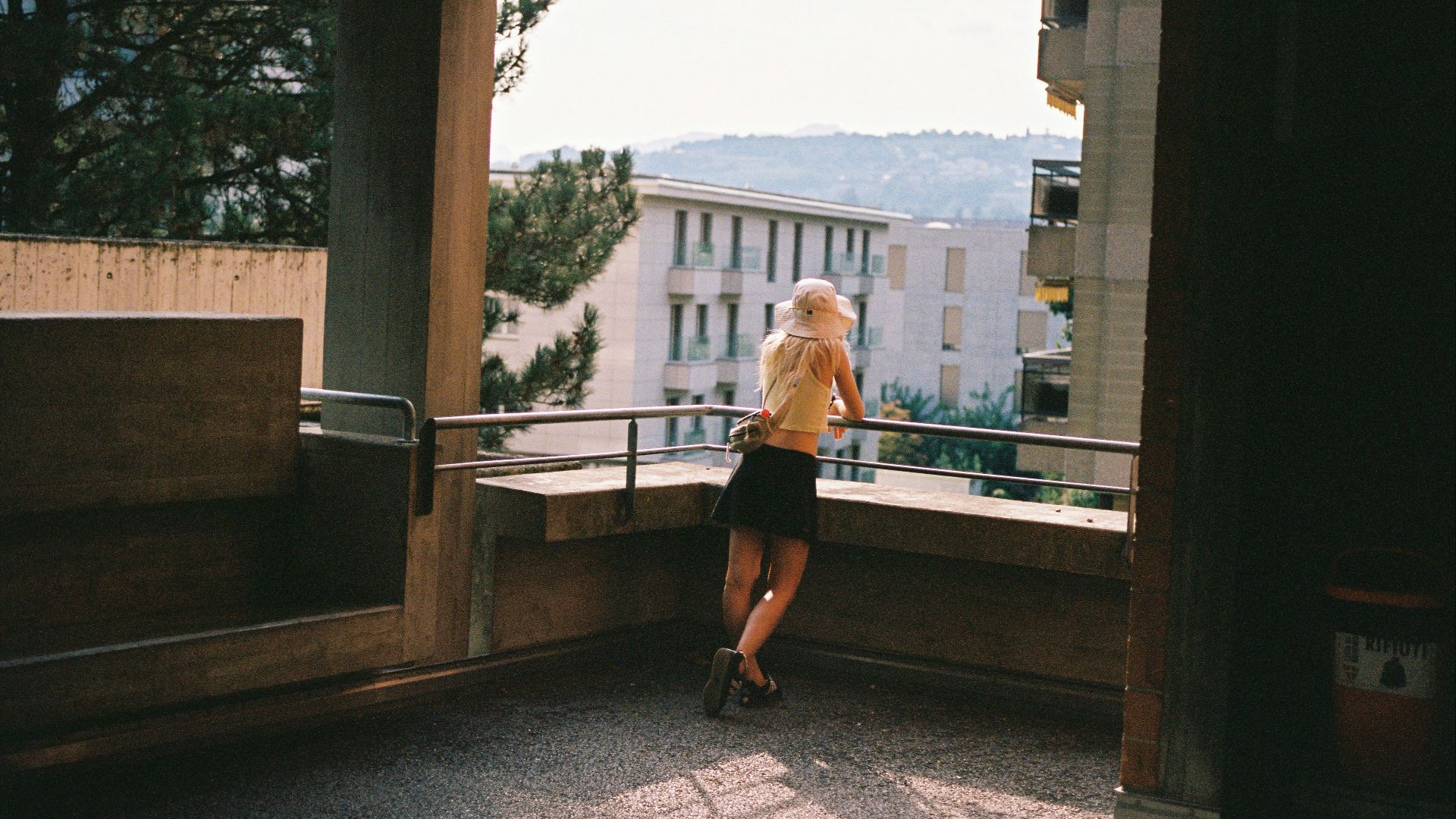 A woman standing on a balcony looking out at the city