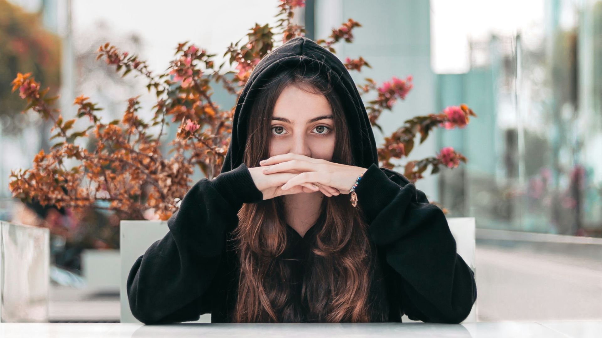 woman in black hooded jacket by brown plant