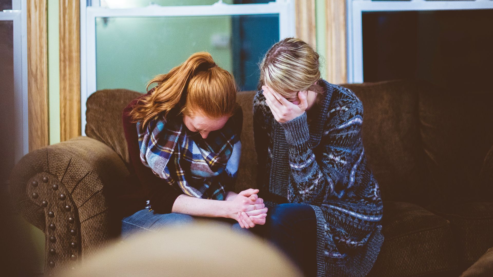 man and woman sitting on sofa in a room