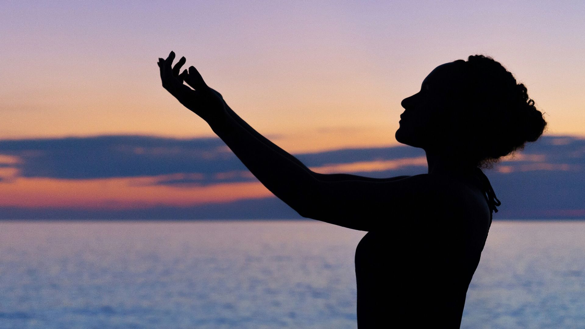 silhouette of woman raising her right hand