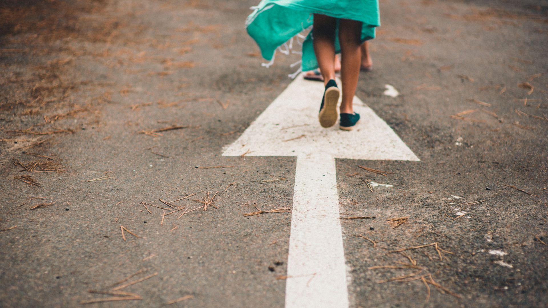 person walking on arrow street sign