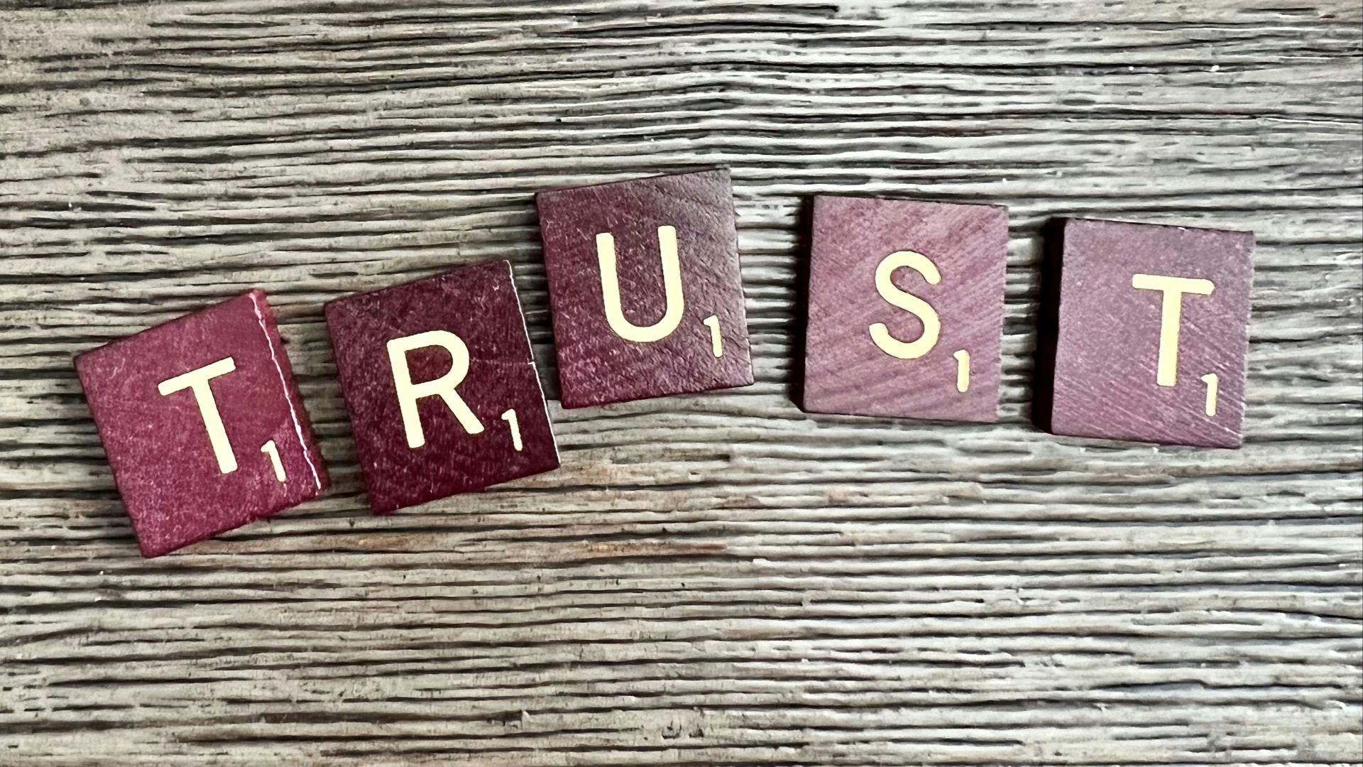 trust spelled with wooden letter blocks on a table