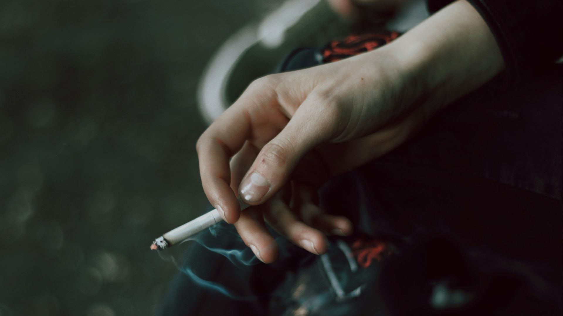 A person holding a cigarette in their hand