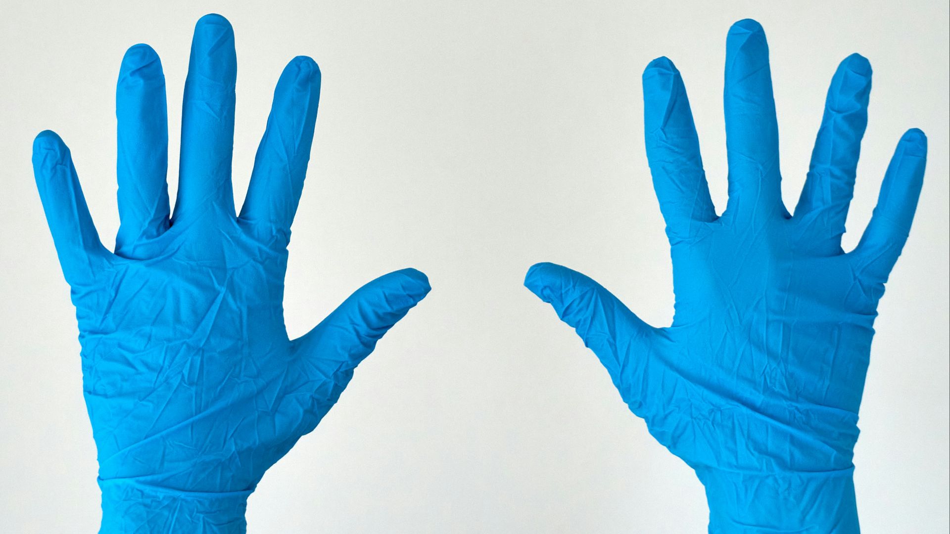 person in blue gloves with white background