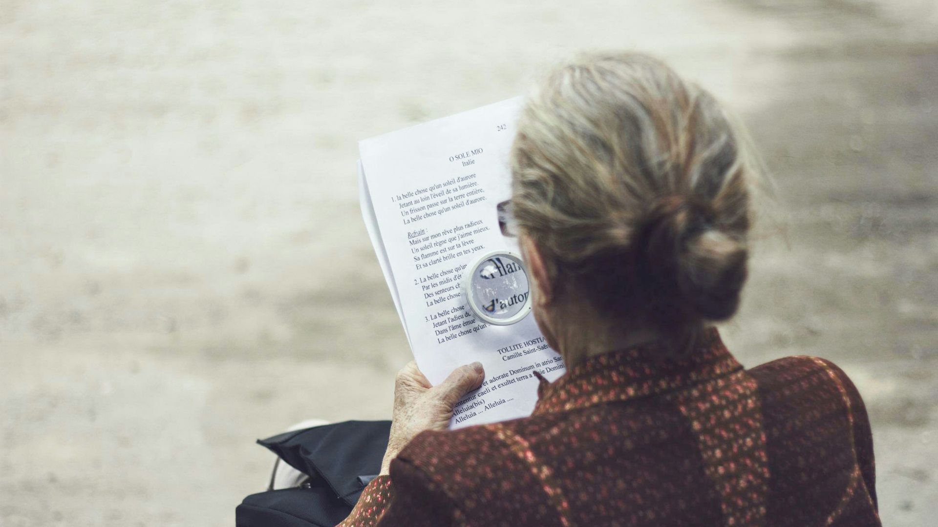 woman in brown top reading paper