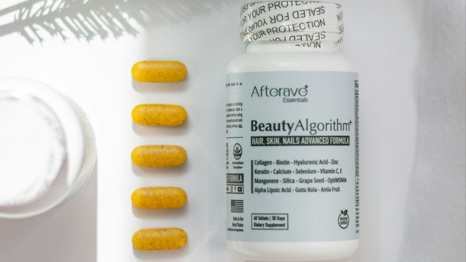 A bottle of vitamin pills next to a plant