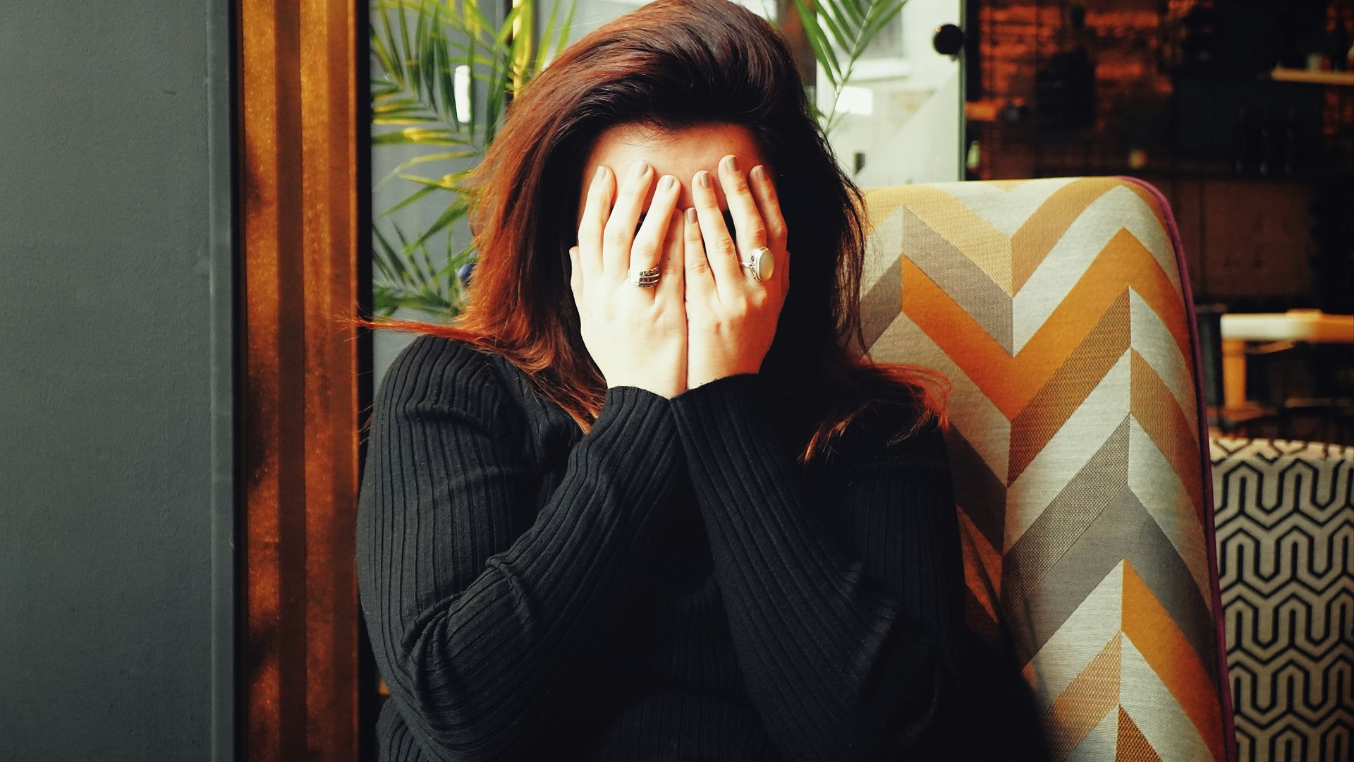 woman in black long sleeve shirt covering her face