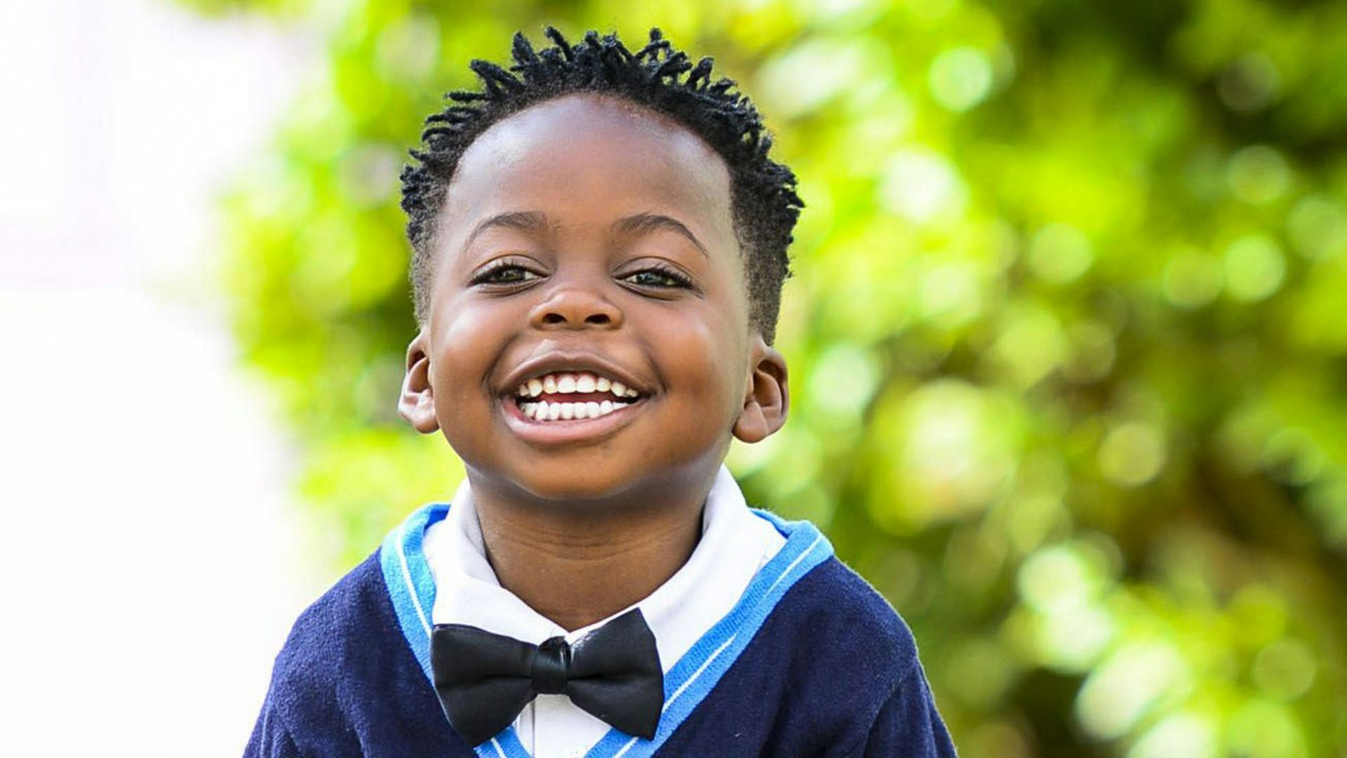 selective focus photo of boy standing on grey pavement