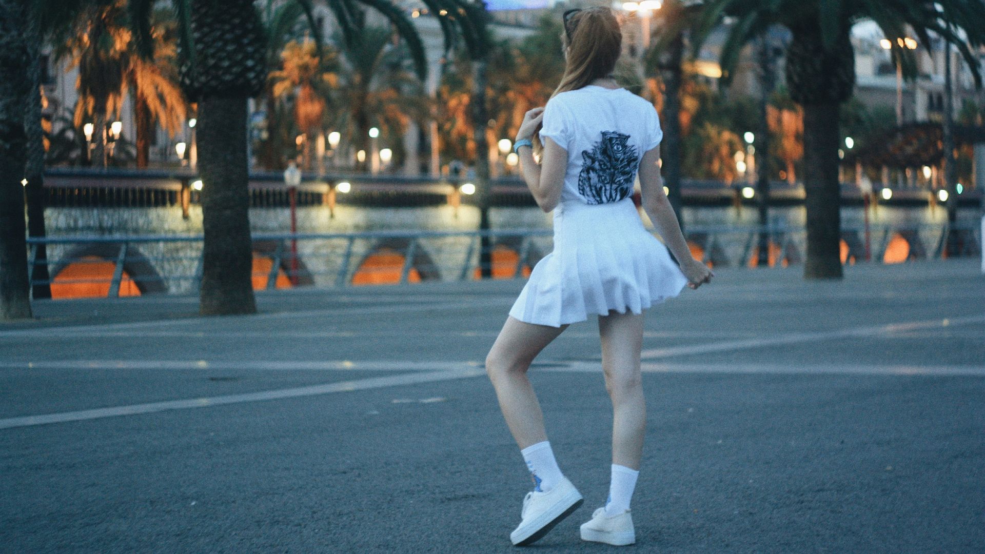 woman wearing white mini skirt standing on concrete surface
