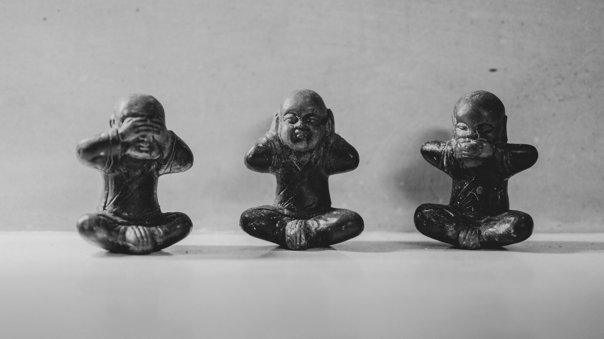 three small figurines sitting in a row