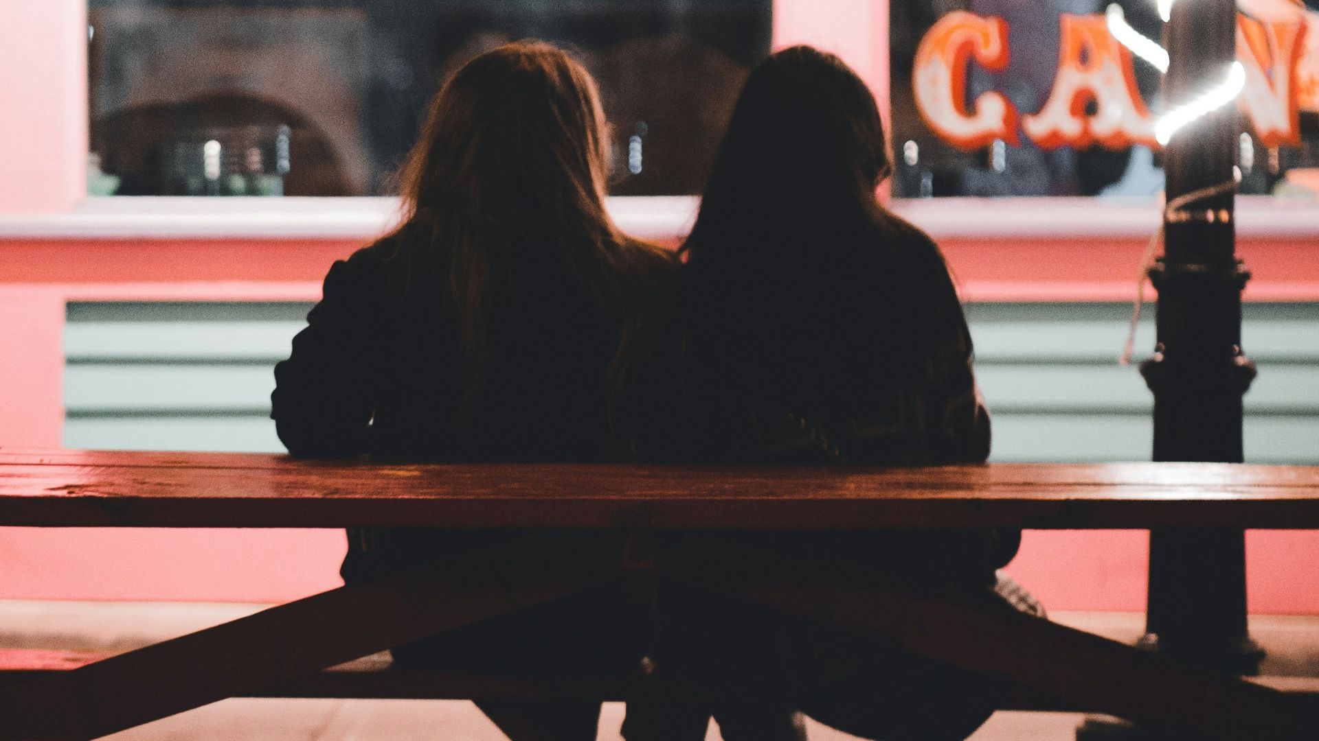 a couple of people sit on a bench