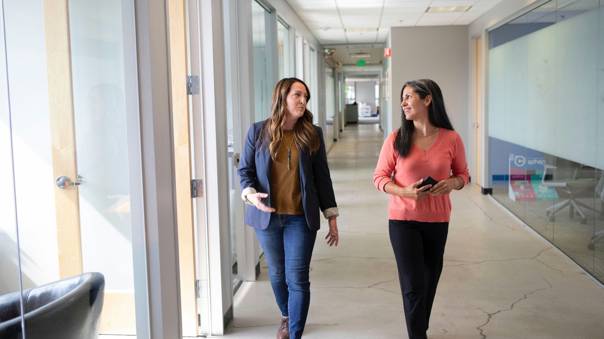 2 women standing near white wall