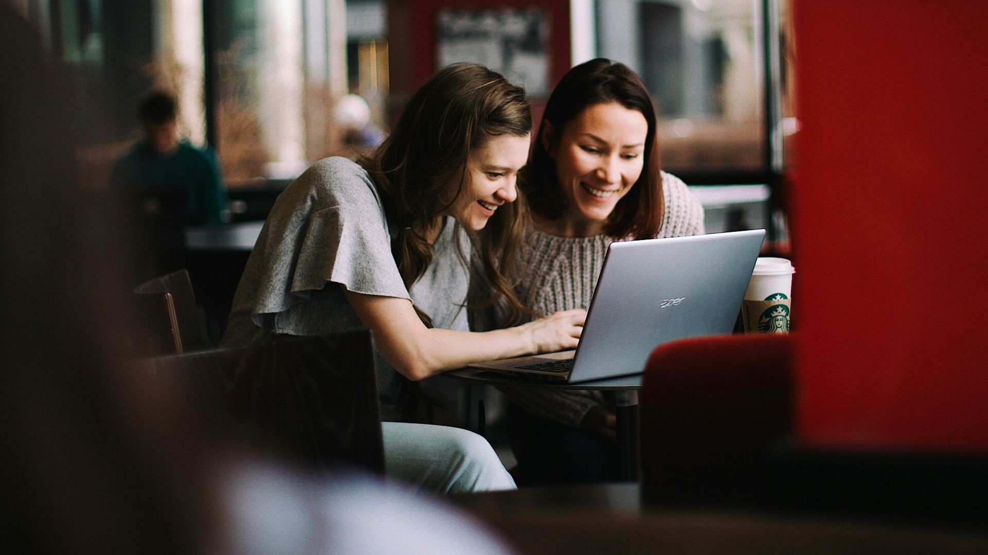 woman in white shirt using macbook