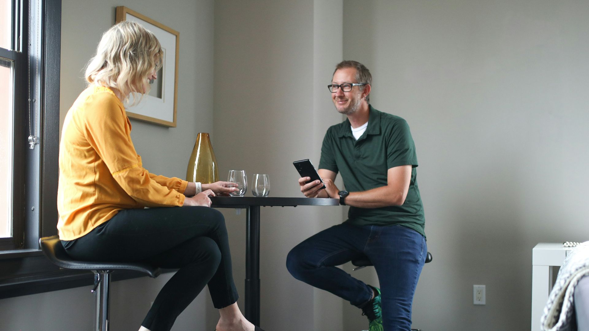 man in green polo shirt sitting beside woman in yellow shirt