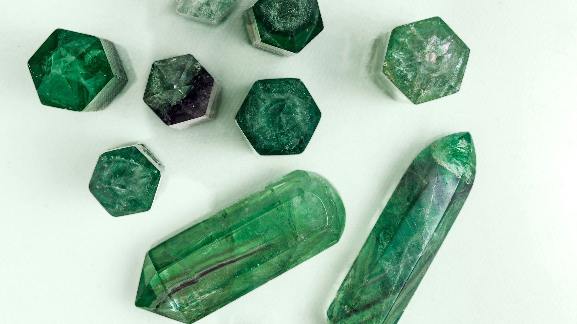 a group of green crystals sitting on top of a white table