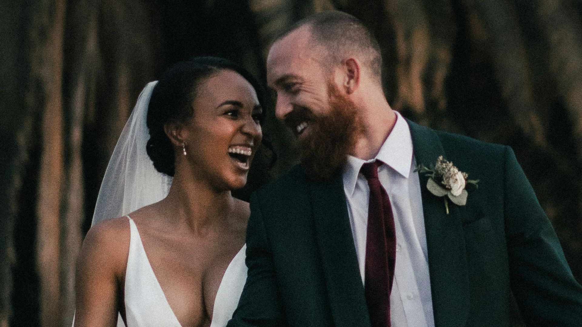 a newly married couple walking through a field