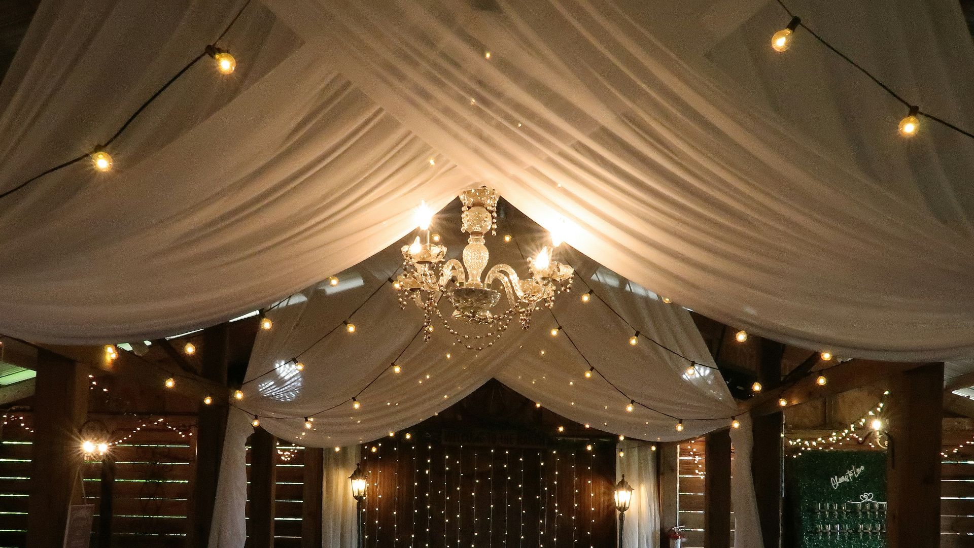 Elegant wedding reception venue with draped fabric and lights