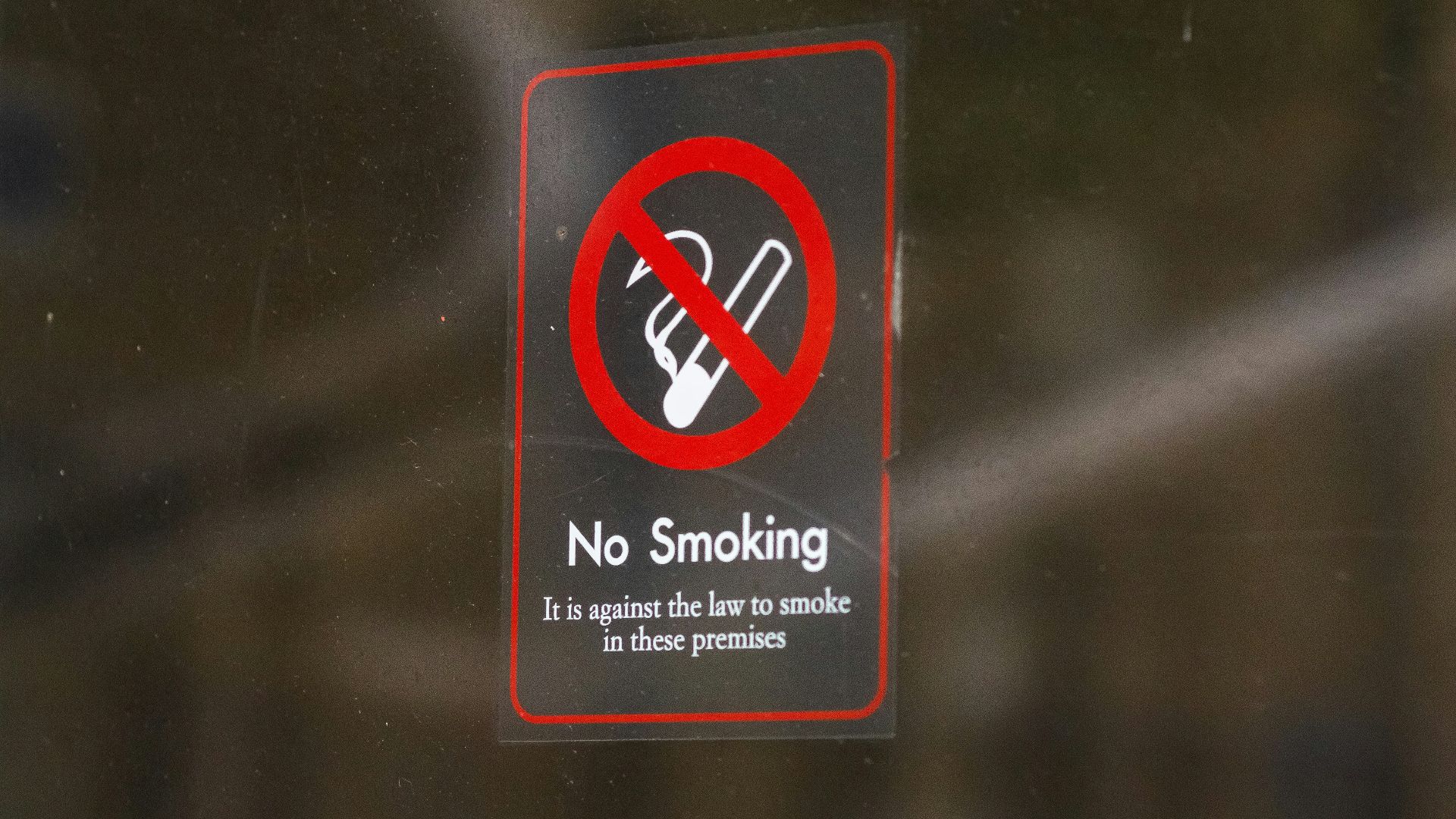 a no smoking sign on a glass door