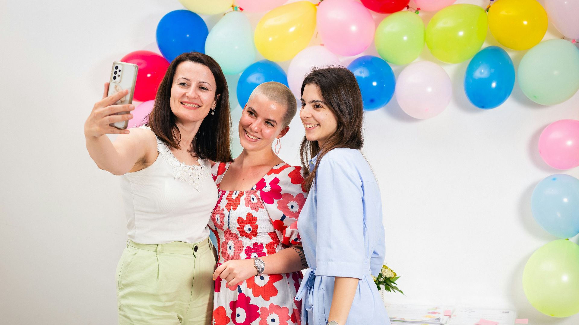 three women taking a picture with a cell phone