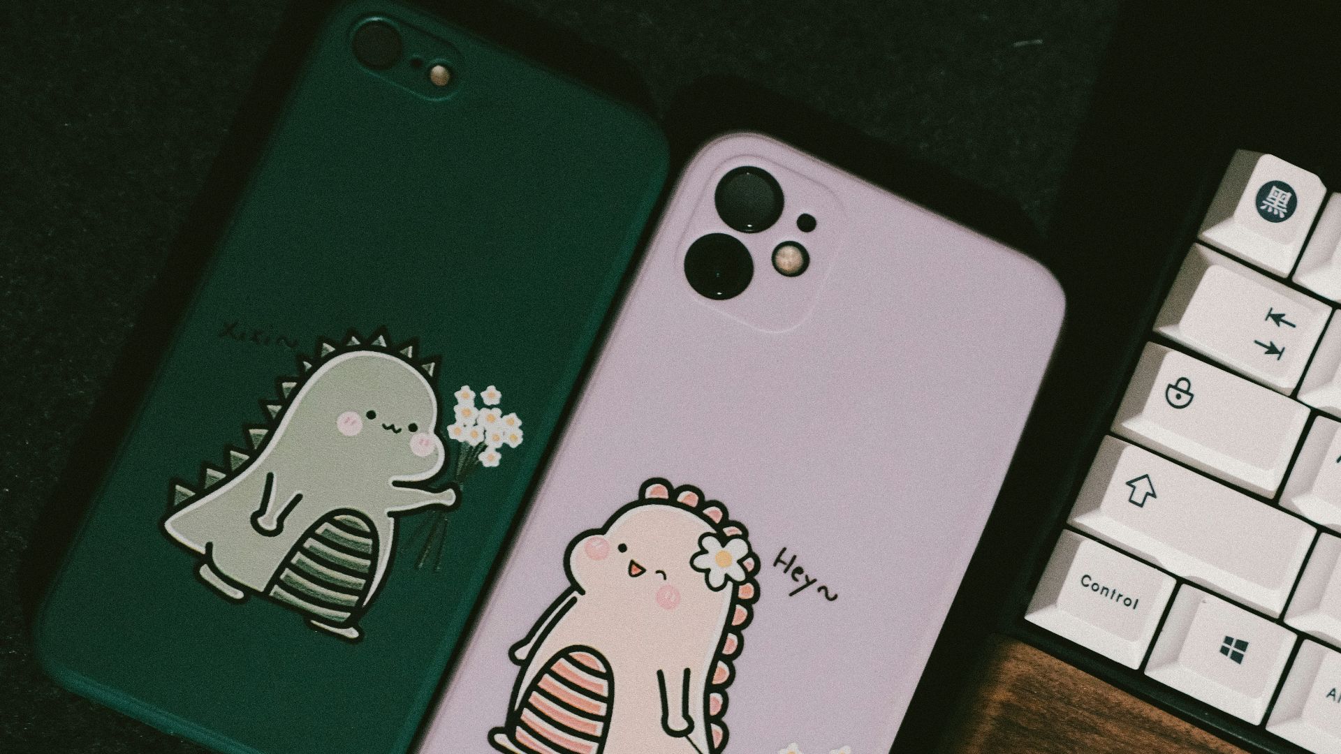 a couple of cell phones sitting next to a keyboard