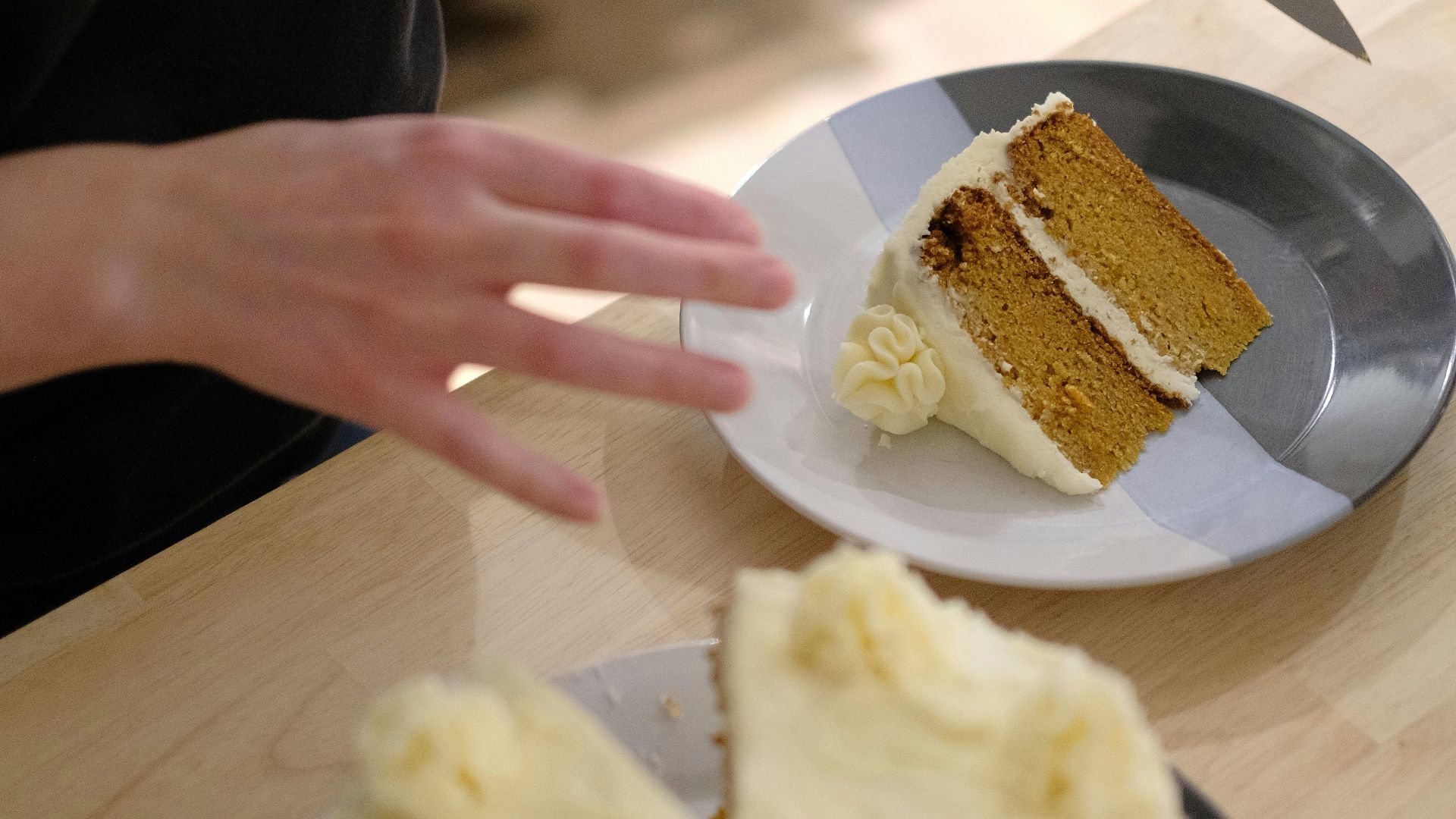 A person cutting a piece of cake with a knife