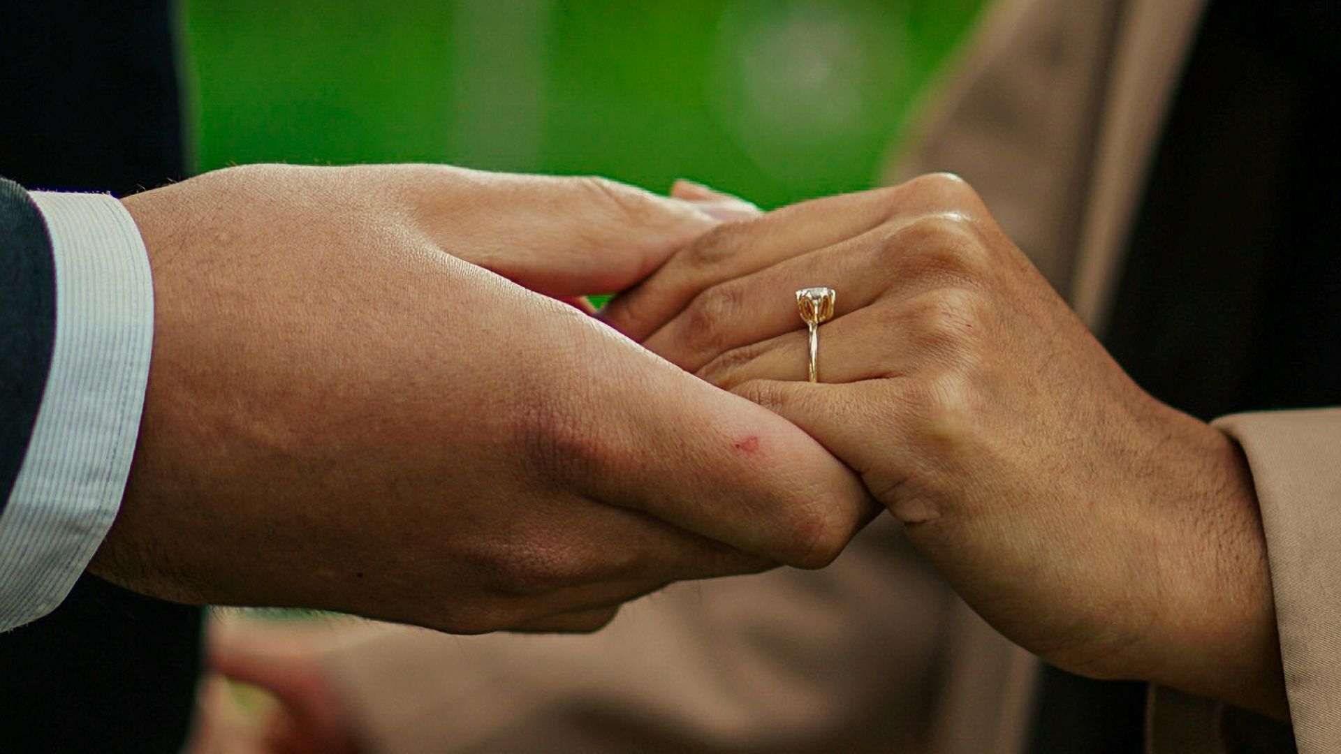 a close up of two people holding hands
