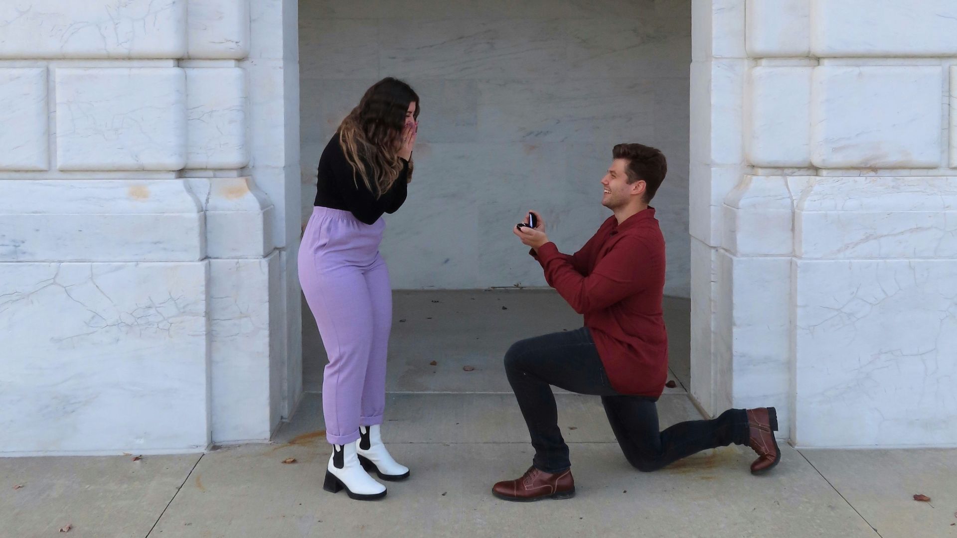 man and woman sitting on concrete bench
