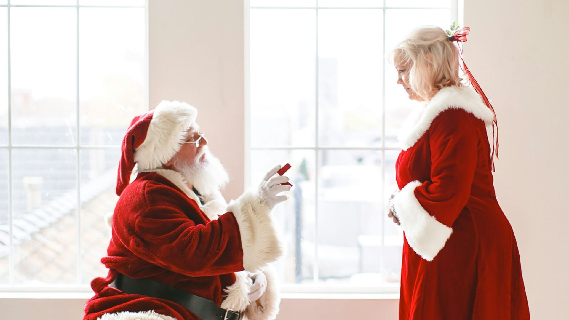 a little girl dressed as santa claus and a man dressed as santa claus