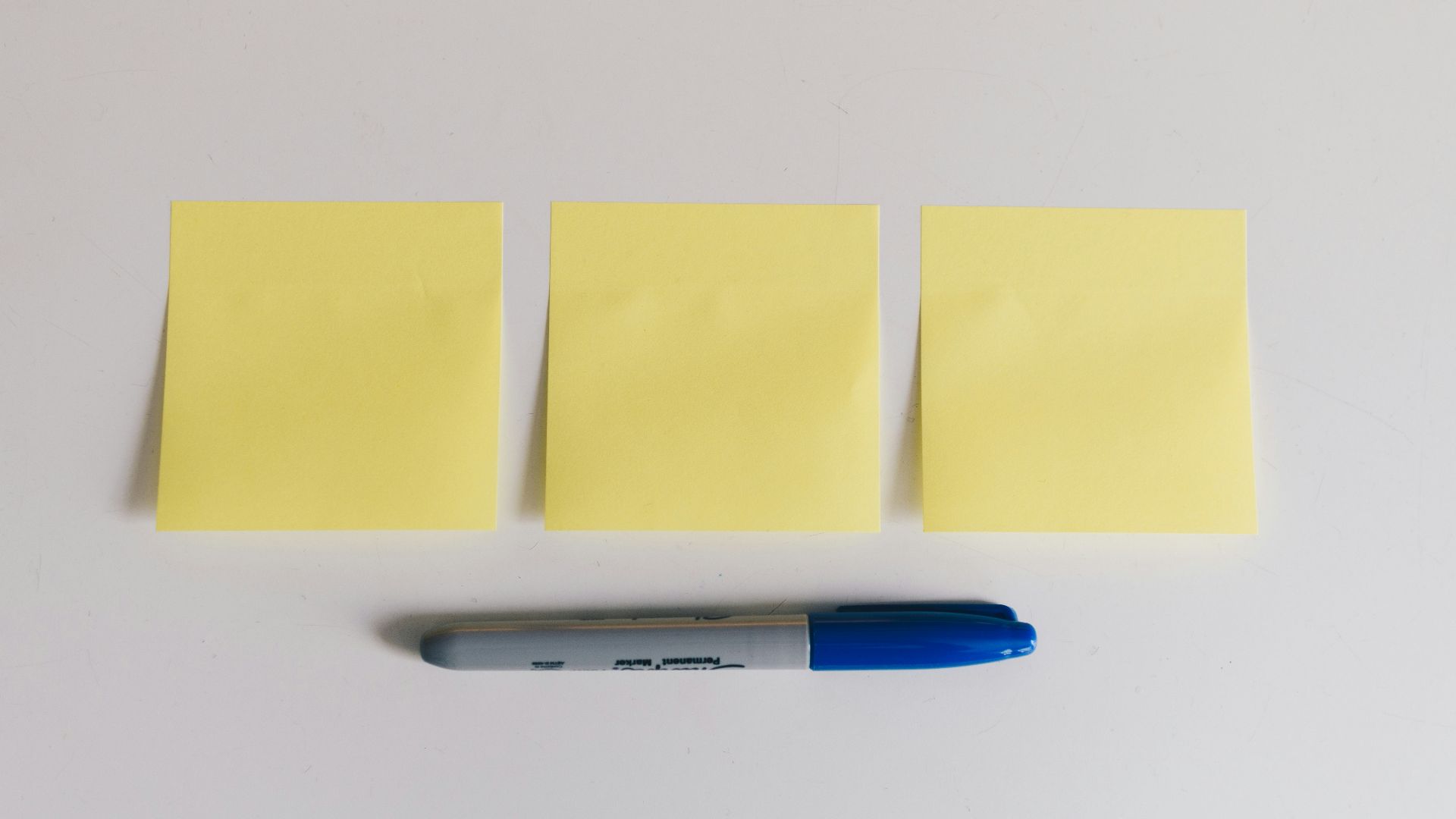 blue sharpie beside yellow sticky notes