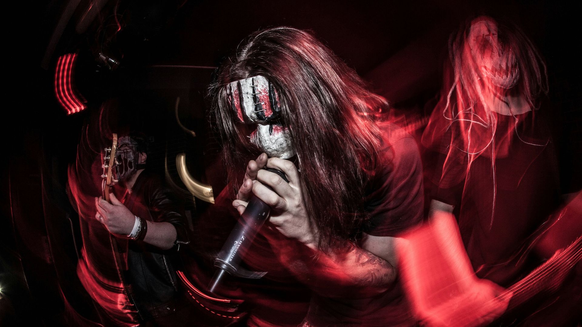 a man with long hair holding a microphone