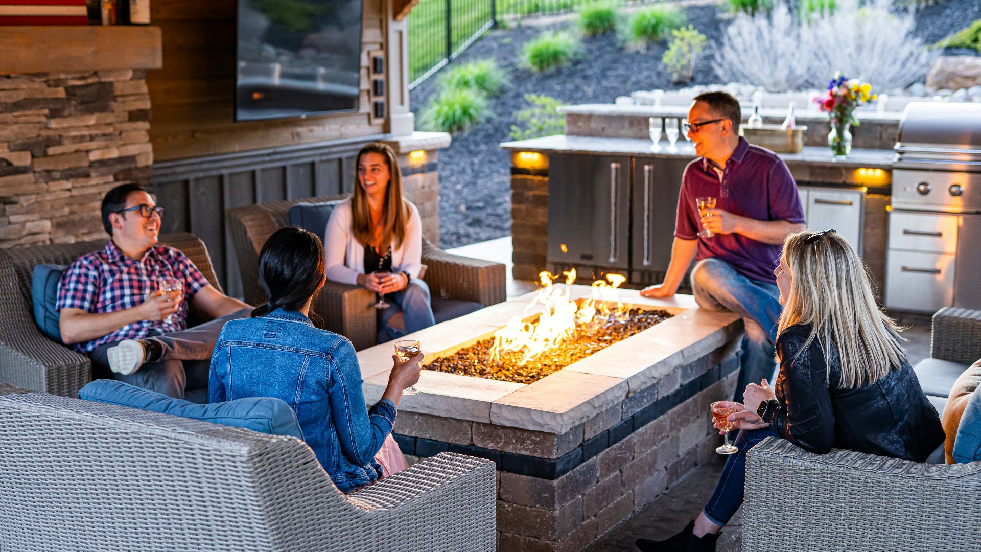 a group of people sitting around a table with a fire in it