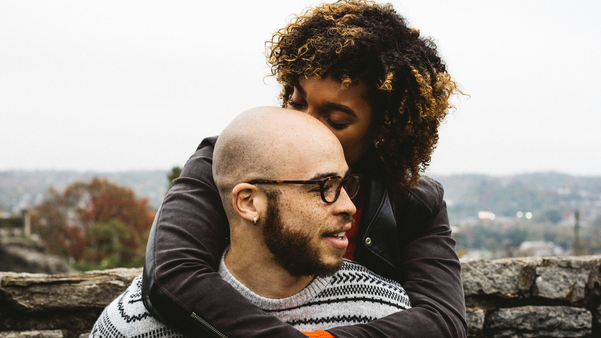 woman kissing man's head