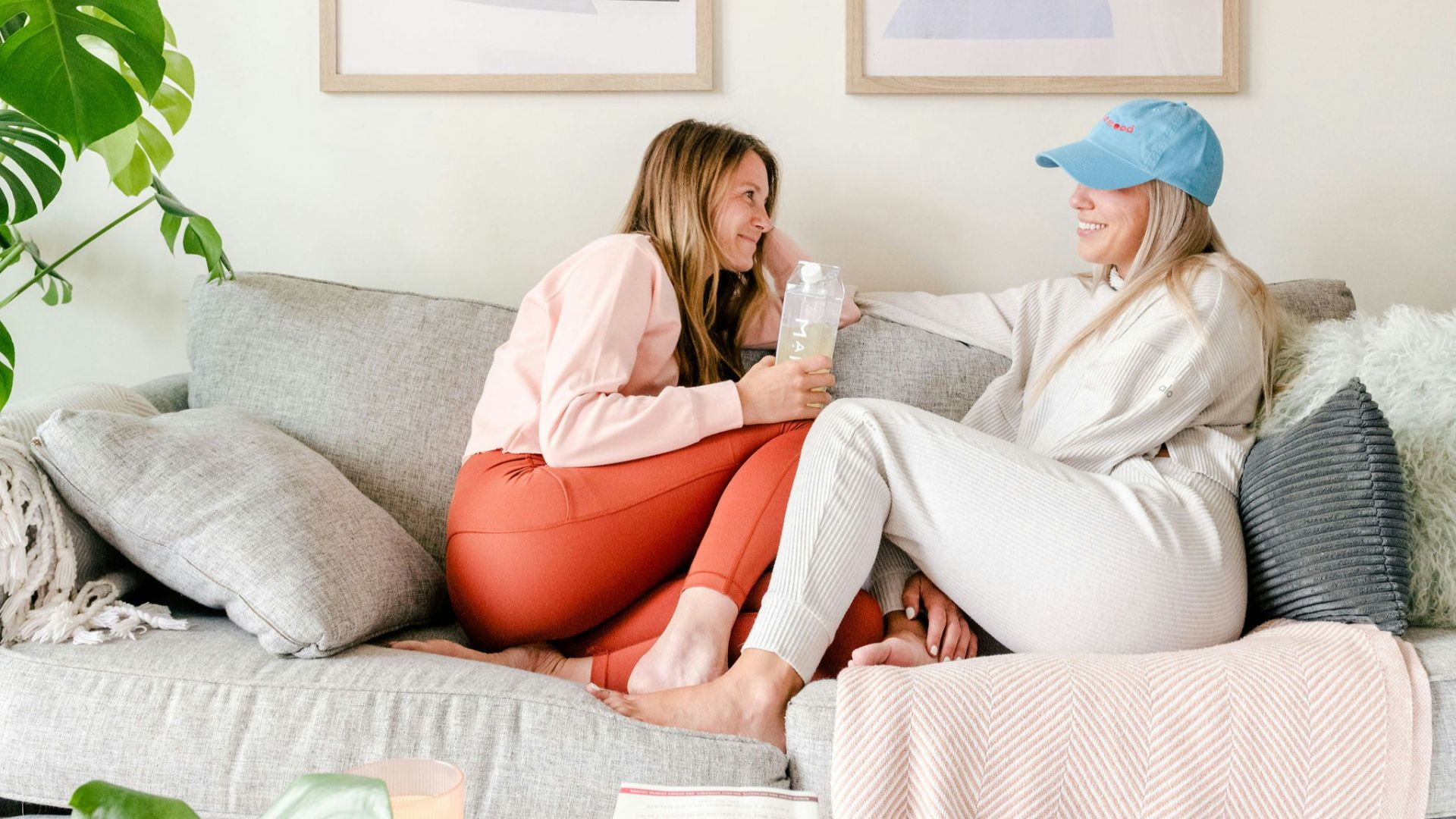 two women sitting on a couch in a living room