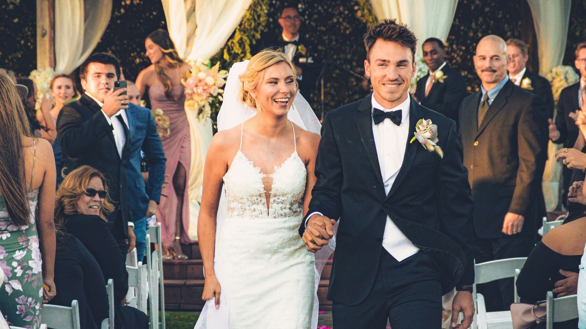 a bride and groom walking down the aisle