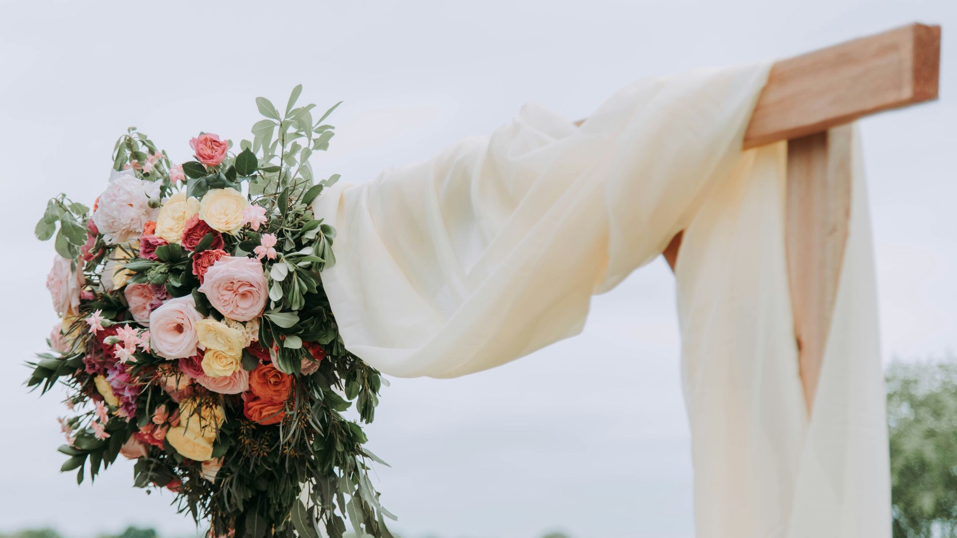 bouquet of assorted-color flowers hanged on brown plank with white textile