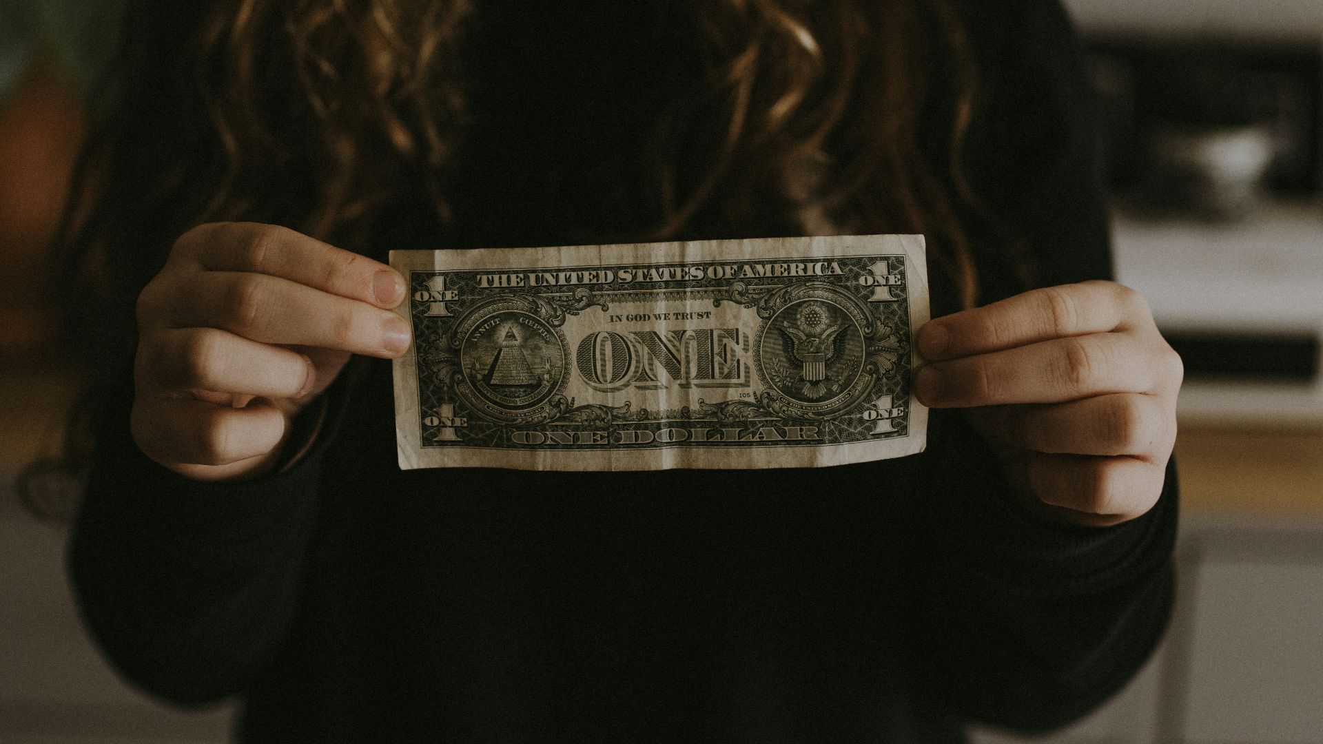girl holding 1 U.S. dollar banknote
