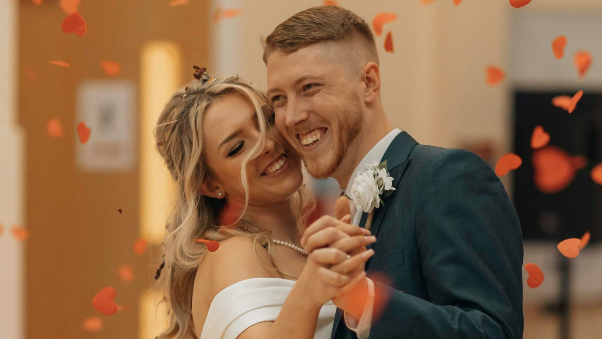 A bride and groom are posing for a picture