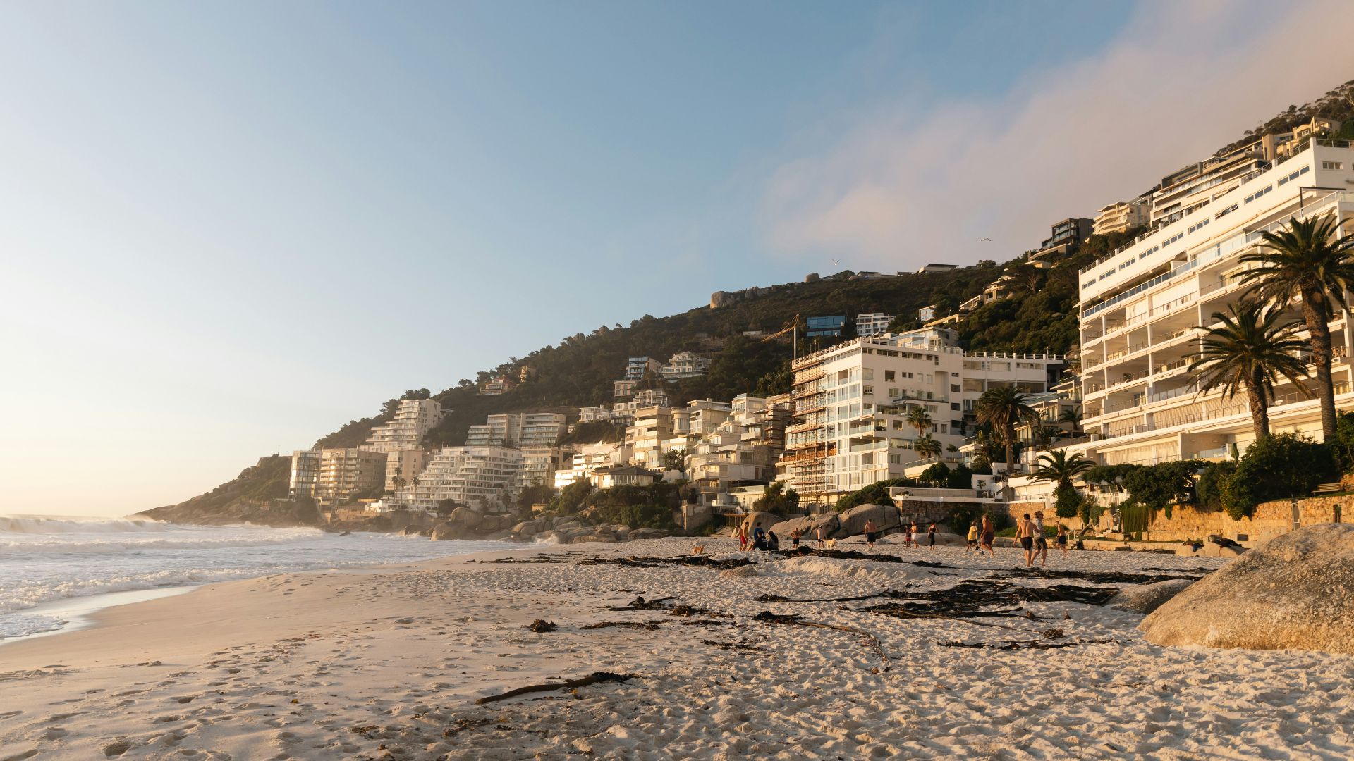 Beachfront buildings line the coast at sunset.
