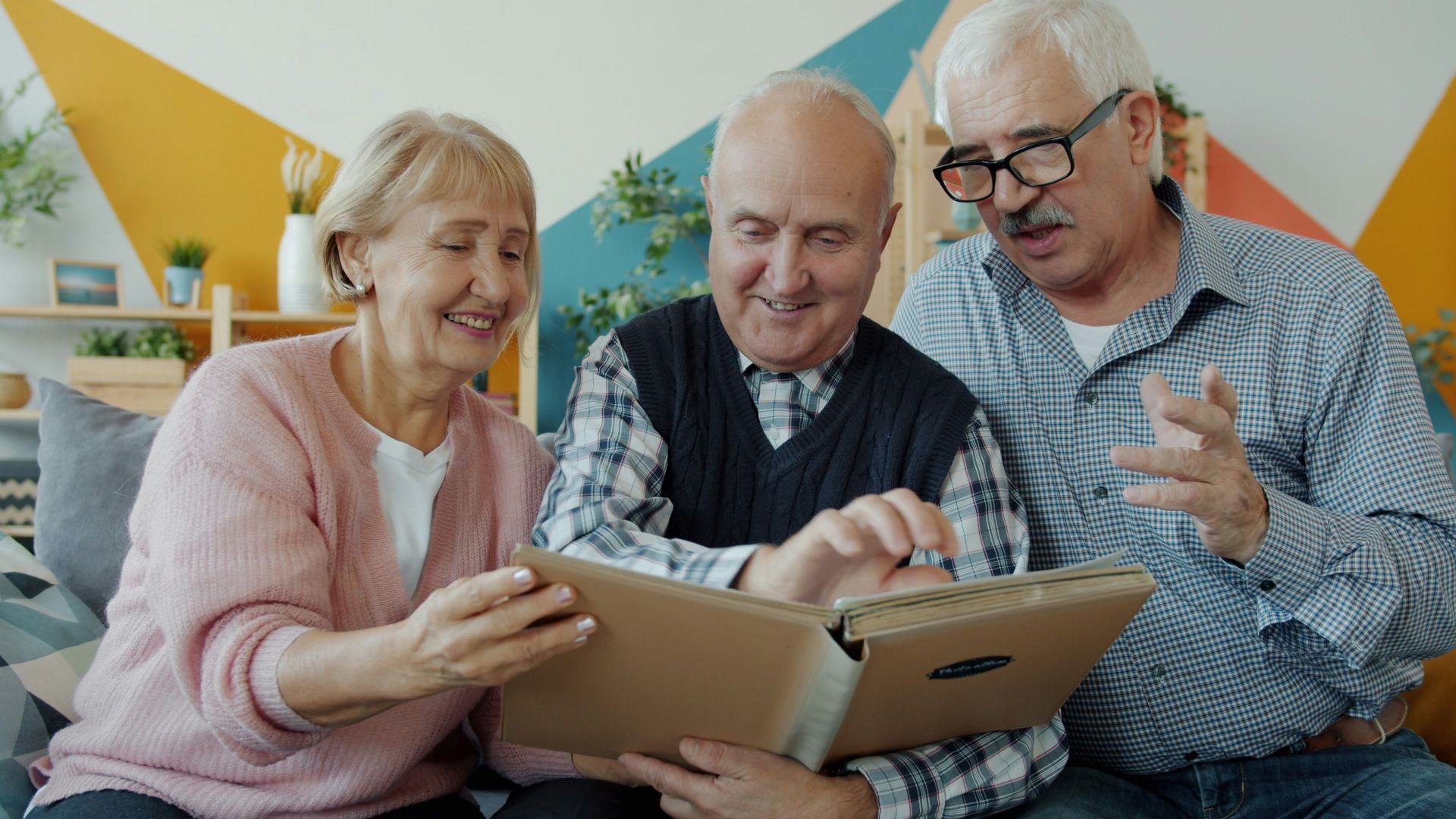 Three seniors looking at a photo album together