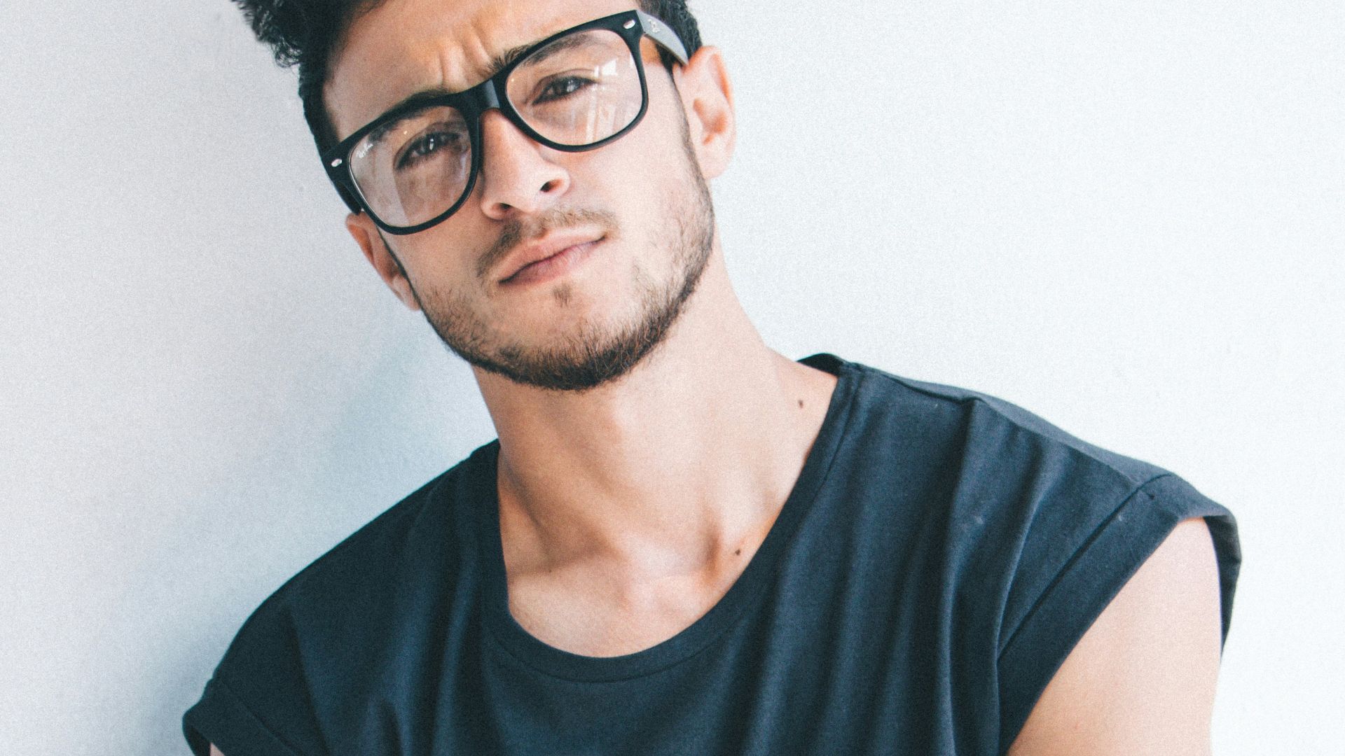 man wearing eyeglasses and sleeveless top