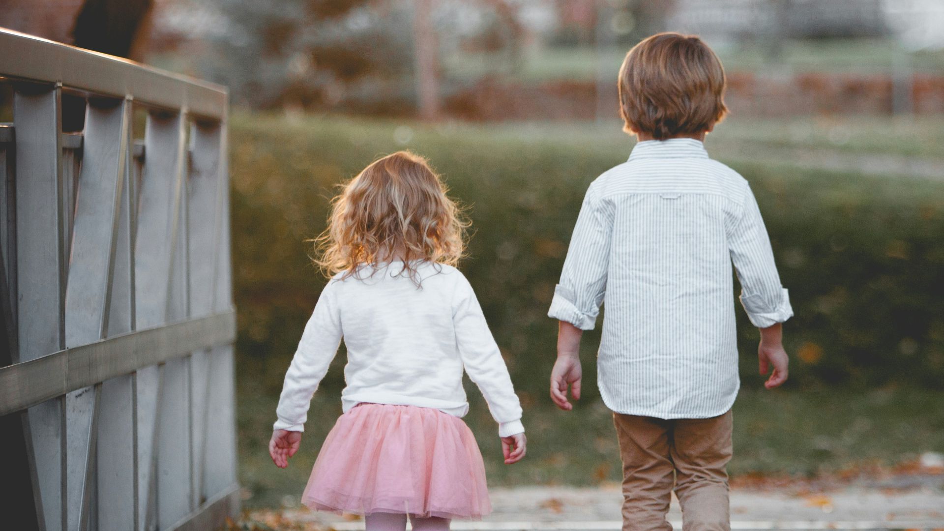 boy beside girl walking near railing