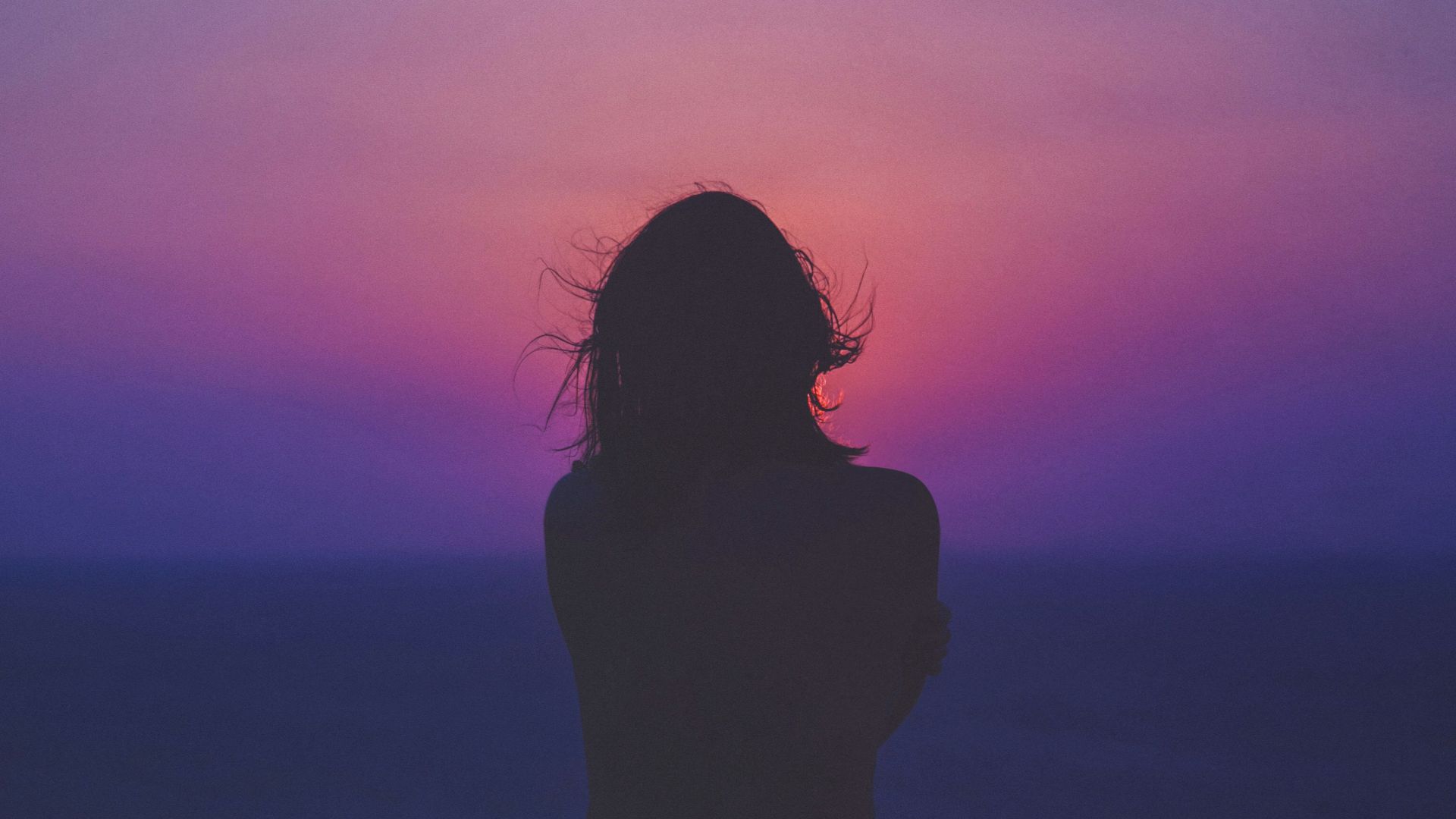silhouette of a woman with pink and purple sky